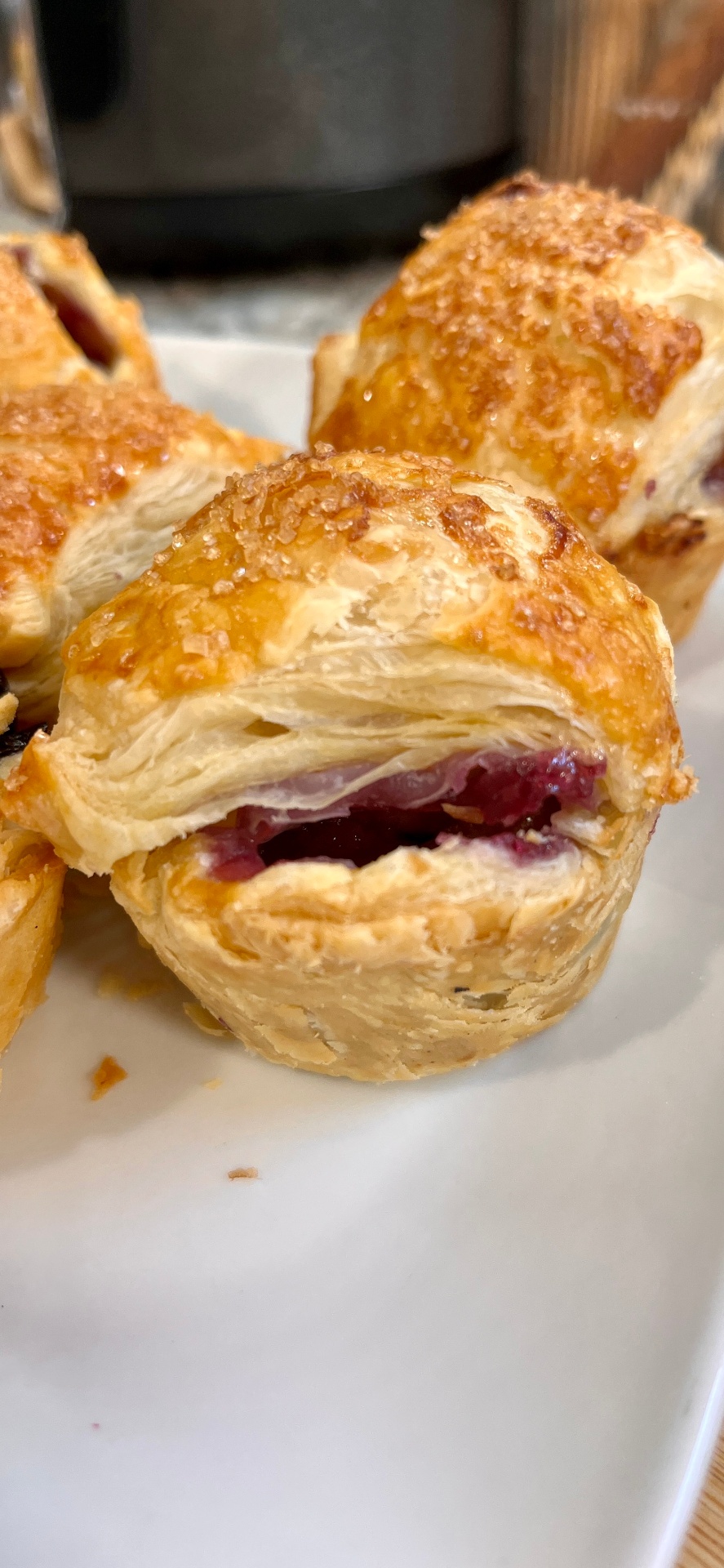Golden flaky layers of the hand pie showing jammy blueberry filling