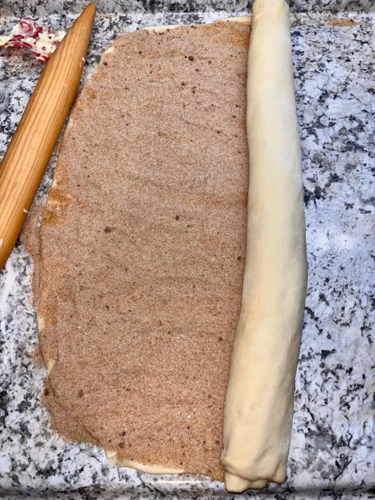 Rolling up the cinnamon roll dough with filling