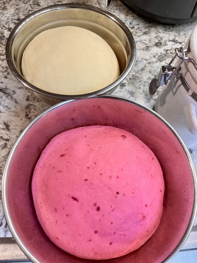 Pink beetroot dough and white dough rising in separate bowls